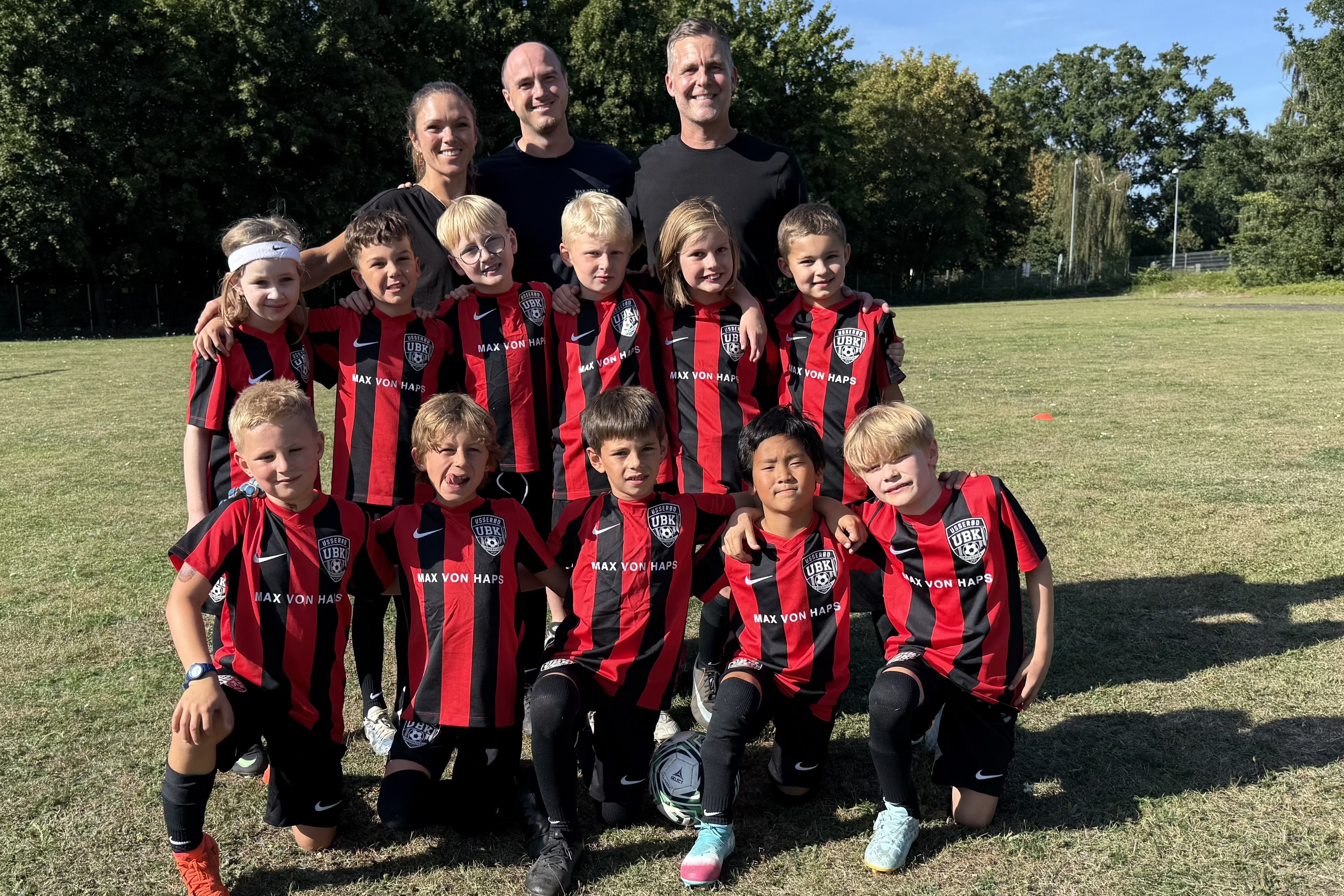 Hørsholm nye fodboldklub har fået lokal bager som sponsor. Her ses et af holdene med træner Camilla Bendix (til venstre), sponsor Max Hoffmann-Dose (i midten) og træner Allan Priess Poulsen (til højre) på bageste række.