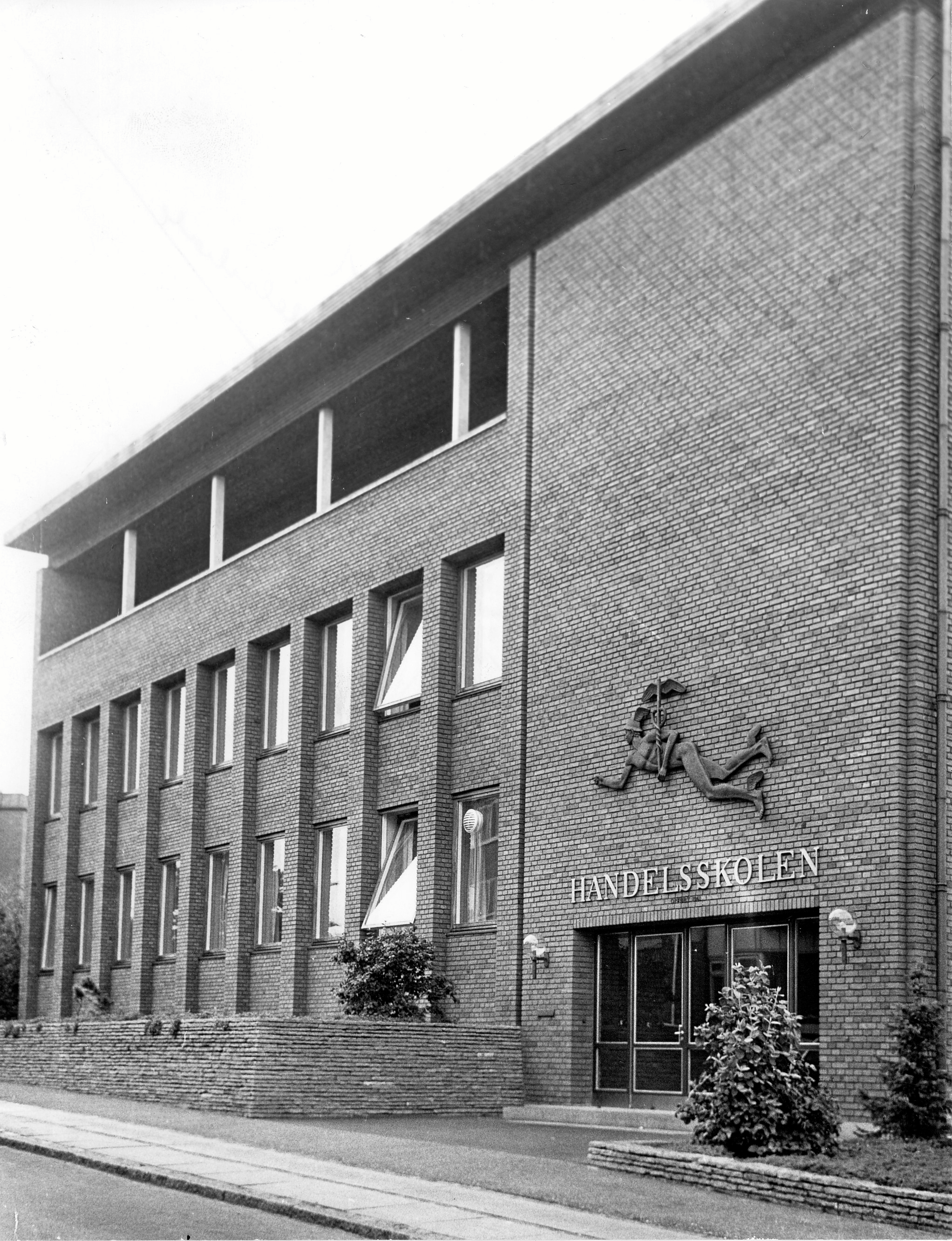 Handelsstandsforeningens skolebygning i Torvegader, som husede handelsskolen. Over døren ses Hermes. Hermes er i den græske mytologi handelens, købmændenes og tyvenes gud. Da handelsskolen flyttede til Willemoesvej tog den relieffet med.