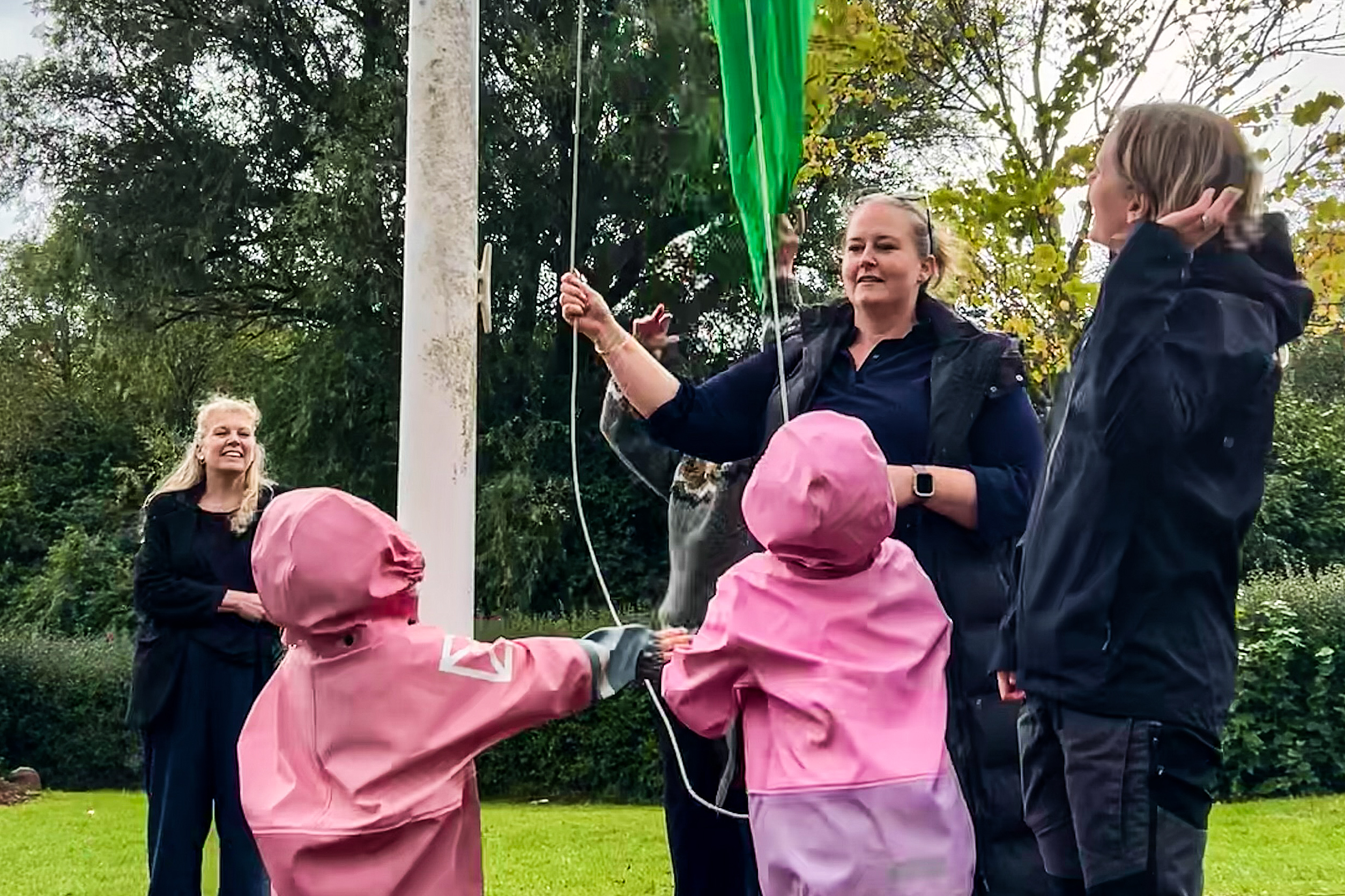 Lederen af Tungegården, Tanya Eya Mortensen, holder flaget, mens Egedal-borgmester Birgitte Neergaard-Kofod ser på i baggrunden.
