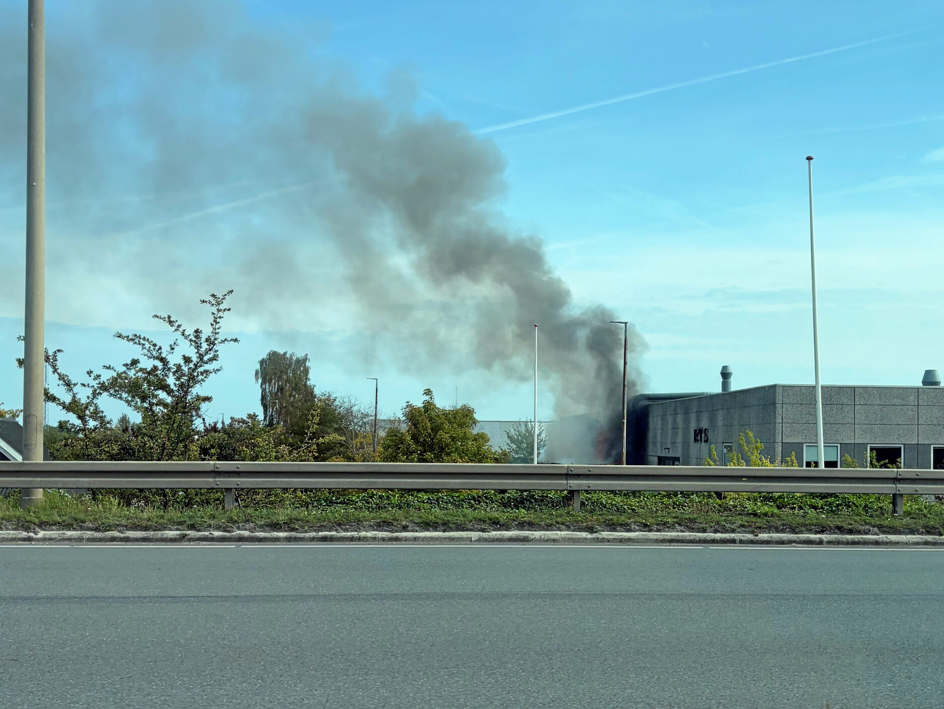 Sort røg vælter ud fra en bygning på teknisk skole her kort før kloken 14.30.